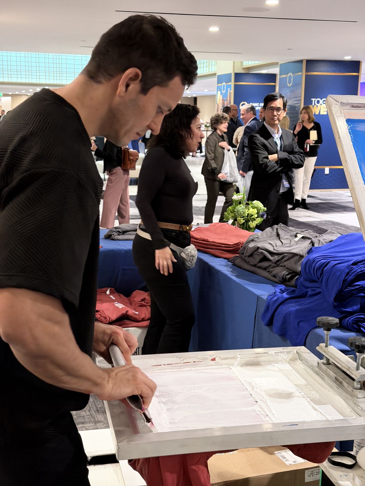Guests watching custom merch get printed live at a Philadelphia event